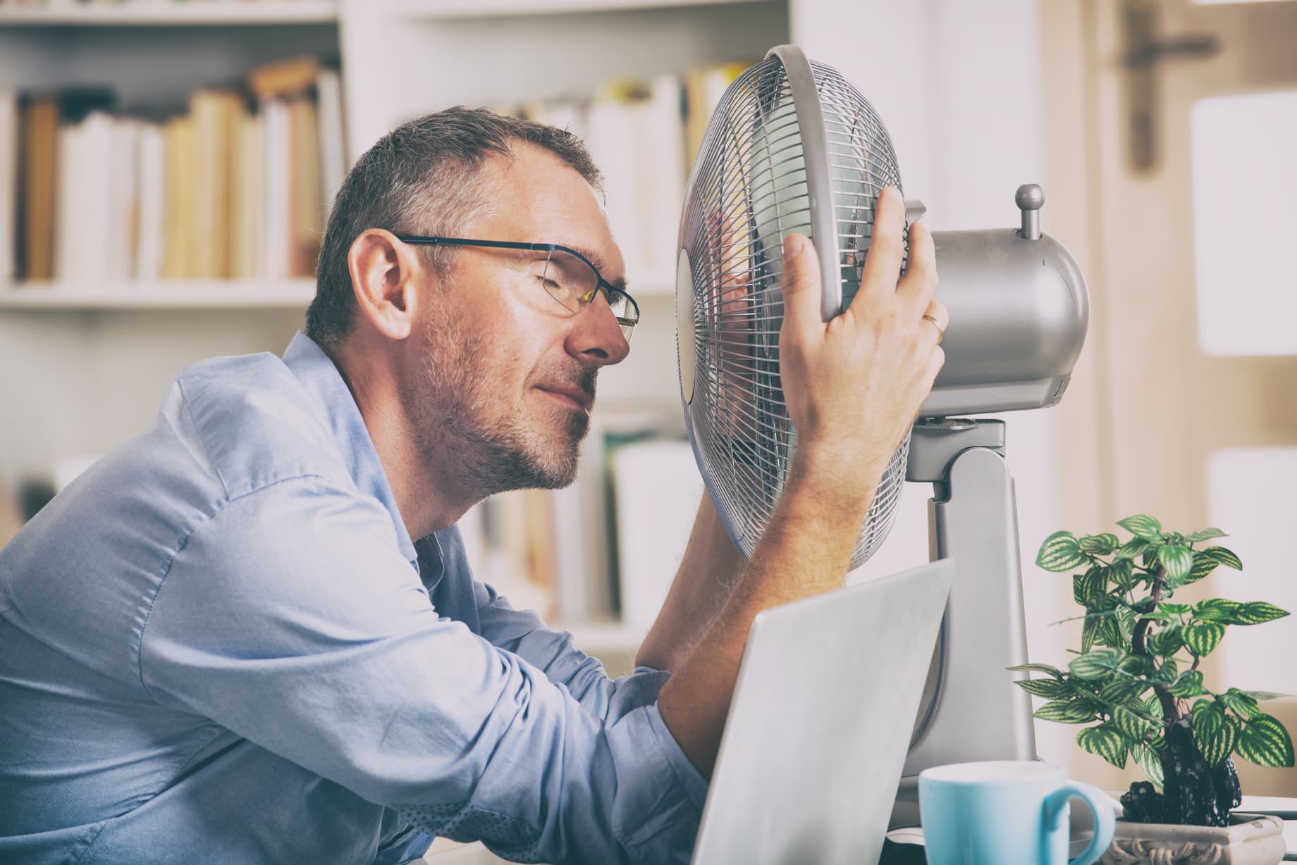 Blog - Mann mit Ventilator im Sommer