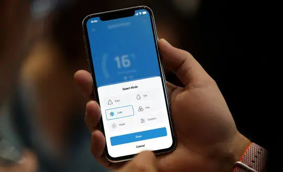 Smartphone mit Danyon Smart Control App zur Klimaanlagensteuerung, moderne Klimageräte.